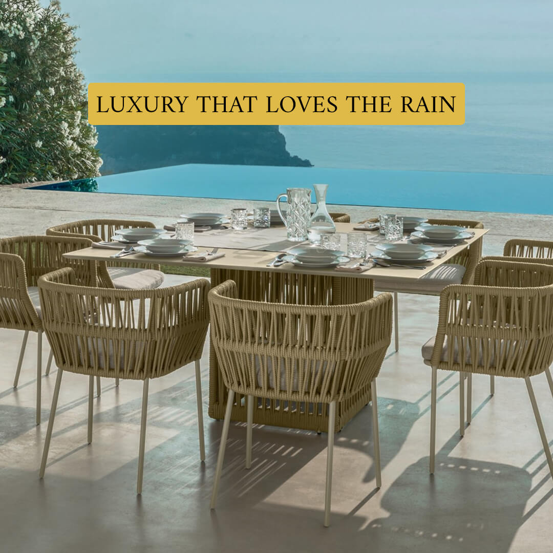 Loom Crafts Outdoor Garden Furniture A modern outdoor daybed with wicker detailing is positioned near the ocean shore on a wooden deck, accompanied by text overlay stating "LIFE TIME WARRANTY".