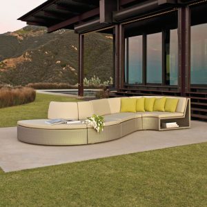 Loom Crafts Outdoor Garden Furniture A curved sectional sofa on a grassy area in front of a house.