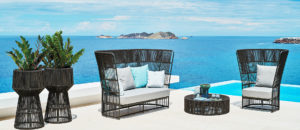 Loom Crafts Outdoor Garden Furniture A wicker furniture set on a patio with a view of the ocean.