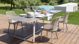 Loom Crafts Outdoor Garden Furniture An outdoor table and chairs on a wooden deck.