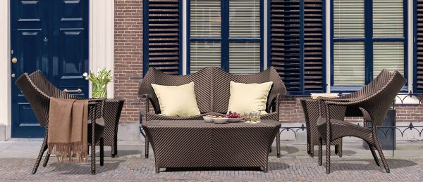 Loom Crafts Outdoor Garden Furniture A wicker patio furniture set in front of a building.