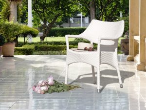 Loom Crafts Outdoor Garden Furniture A white wicker chair sitting on a tiled patio.