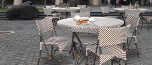 Loom Crafts Outdoor Garden Furniture A set of outdoor chairs and tables on a cobblestone street.