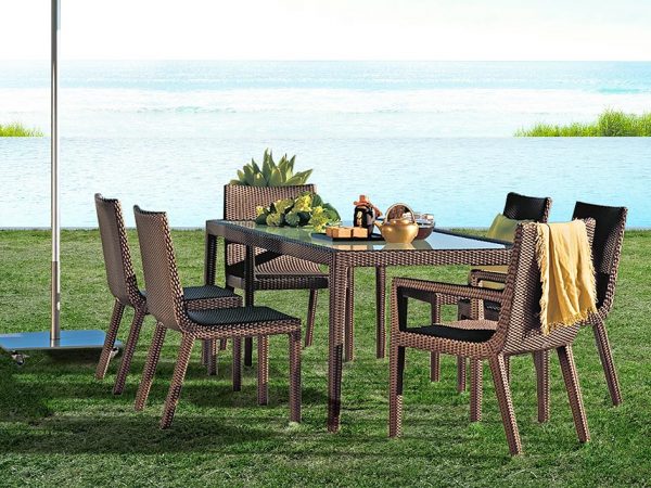 Loom Crafts Outdoor Garden Furniture A wicker dining table and chairs on a grassy area.