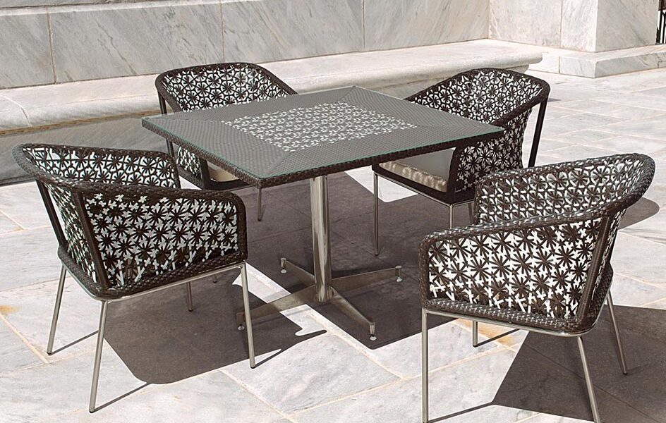 Loom Crafts Outdoor Garden Furniture A table and DINING ARMCHAIRS WITH CUSHIONS (LCOD/202/001) on a stone patio.