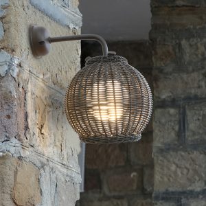 Loom Crafts Outdoor Garden Furniture A wicker outdoor wall light on a stone wall.