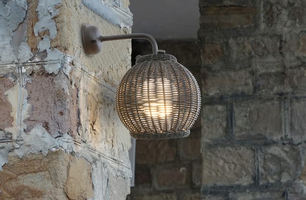 Loom Crafts Outdoor Garden Furniture A wicker outdoor wall light on a stone wall.