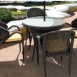 Loom Crafts Outdoor Garden Furniture A wicker DINING TABLE WITH GLASS TOP (LCOD/143/002) and chairs with umbrella.