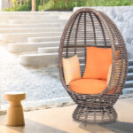 Loom Crafts Outdoor Garden Furniture A rattan OVAL CHAIR WITH CUSHIONS (LCO/073/001) with orange cushions.