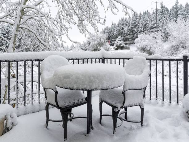 Loom Crafts Outdoor Garden Furniture A table and chairs covered in snow on a deck.