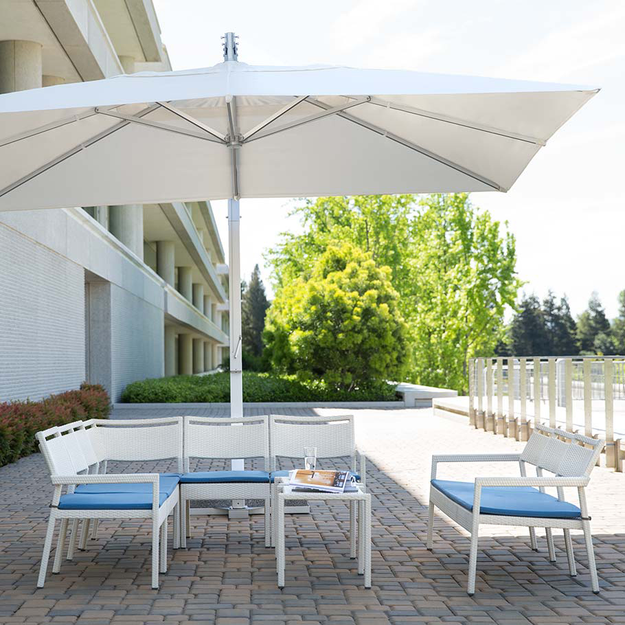Loom Crafts Outdoor Garden Furniture A white patio set with a blue umbrella.