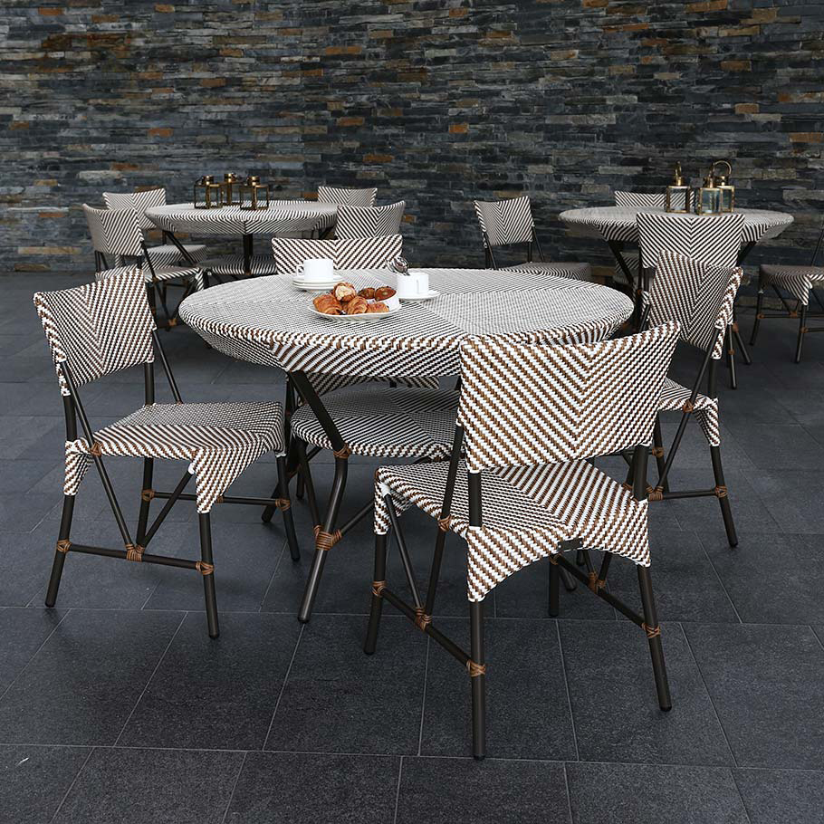 Loom Crafts Outdoor Garden Furniture An outdoor dining table and chairs with a stone wall.