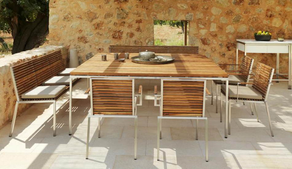 Loom Crafts Outdoor Garden Furniture A wooden dining table and chairs on a patio.